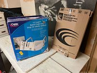 Carex raised toilet seat box and Centoco seat carton on table