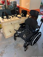 Helio wheelchair with footrests displayed on cabinet