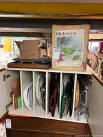 Cabinet with platters, cutting boards, trays; punch set box on top