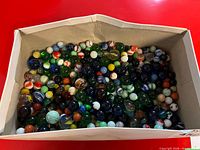 Full view of box filled with mixed glass marbles