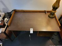 Top view of MDF desk showing surface, raised back rail, dimensions tag