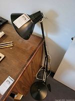 Full view of black metal adjustable lamp beside desk