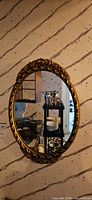 Front view of oval wood framed mirror on wall