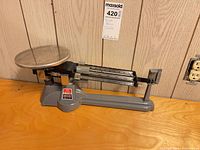 Full view left side of Ohaus triple beam balance on wooden surface