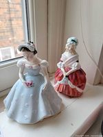 Front view of both Royal Doulton figurines on windowsill