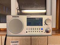 Front view showing Sangean WR-2 display illuminated on AM 1112, speaker grille, controls
