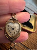 Front view of Buren heart-shaped watch held in hand