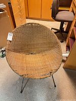 Front view of round wicker chair showing overall form and metal legs