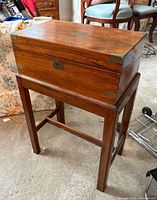 Closed cabinet on stand showing overall form and brass corners