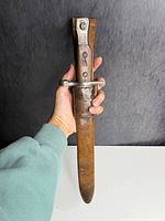 Bayonet inside brown sheath held vertically