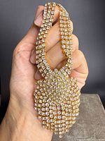 Full view of rhinestone bib necklace held to show design