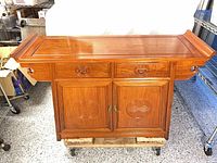 Front view of sideboard showing drawers, doors, carved medallions, brass latch