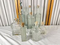 Group view of nine embossed glass bottles with corks