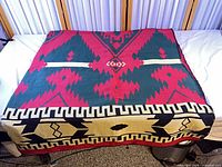 Full view of folded blanket showing multicolor Southwestern design