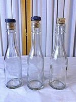 Front view of the three clear glass bottles standing side by side