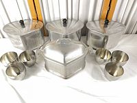 Three aluminum pots with lids, hammered roaster, four cups