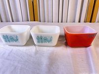 Two Butterprint and one red Pyrex 501 dishes, frontal view