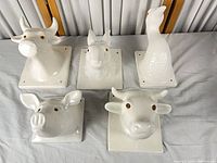 Group shot of five white ceramic animal head plaques