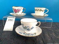 Front view of three teacup and saucer sets on display