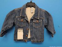 Front view of denim jacket on hanger