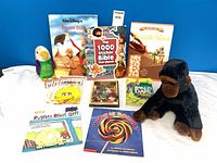 Group shot of all items: plush toys, books, sealed DVD