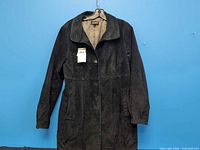 Front view of black suede jacket on hanger