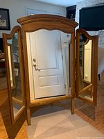 Front view showing central and side mirrors, wood frame, legs