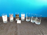 Seven branded highball glasses lined up