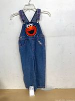 Front view of children’s denim overalls with Grover appliqué