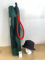Green carry bag with softball swatter and hat overview