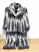Front view of faux fur coat on hanger showing buttons and collar