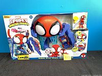 Front of sealed Web-Quarters playset box showing contents and branding