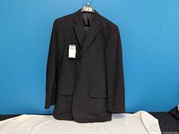 Front view of black jacket on hanger, tag visible