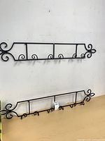 Full view of both matching black metal plate racks on wall