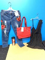 Front view of jeans, purse, dress and travel mug together