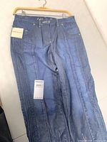 Full view of front of jeans with tags visible