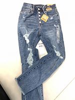 Full view of jeans front showing distressing and button fly