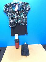 Overall view: top on hanger, gloves, and mug displayed