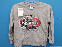 Front view of grey long-sleeve t-shirt with graphic and tag attached