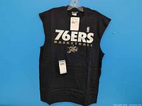 Front view of sleeveless tee with graphics and tags