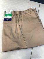 Folded khaki shorts with Classroom Uniforms and Durable tags visible