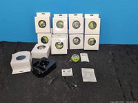 Front view of ten boxed green mini apple speakers with accessories
