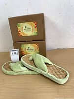 Two soy wax boxes stacked with spa slippers in front