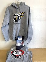 Front view of Titans hoodie, ORHL tee and packaged neck warmer