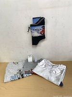 Group shot of folded t-shirts and packaged neck warmer