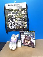 Front view of Duck Dynasty bag, Kodiak socks pack, Wolves book