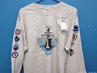 Front view of t-shirt displaying trophy graphic and sleeve logos