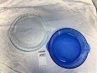 Top view of both pie plates, clear and blue, showing fluted rims and handles