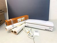 Vacuum sealer, three rolls and boxed roll shown together