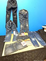 Overall lot view with four jeans, skirt, shorts, phone accessories